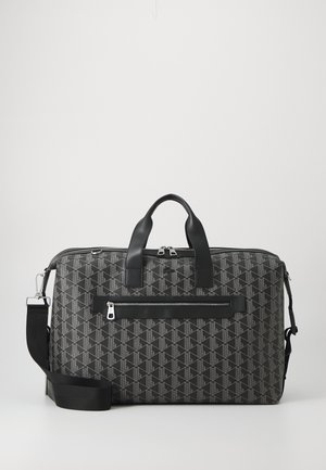 Saco preto com padrão, com detalhes em couro, apresentando duas alças superiores, uma alça de ombro removível e um bolso frontal com fecho.