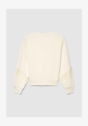 Sweat-shirt couleur crème avec des détails en dentelle élaborés sur les manches, un col arrondi, et des poignets et ourlet côtelés. Texture de tissu doux.