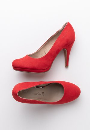 Paire de chaussures à talons hauts en daim rouge pour femmes, une vue de côté et une vue de dessus, sur fond blanc.