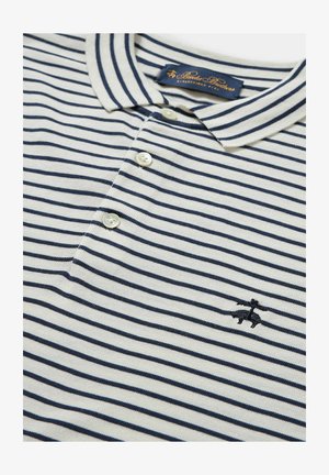 Polo à rayures en crème et bleu marine, avec col, patte de boutonnage à trois boutons et un petit logo brodé sur la poitrine.