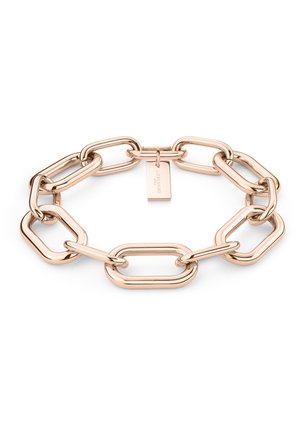 Bracelet en métal bronze constitué de maillons ovales et rectangulaires entrelacés, avec une petite étiquette gravée au nom de la marque.