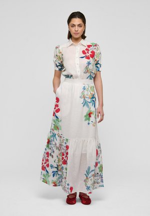 Vestido largo con estampado floral en rojo, verde y azul sobre un fondo claro. Presenta mangas cortas abullonadas, cierre delantero con botones y falda de volantes.