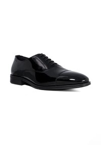 Black leather dress shoe with a glossy finish, round toe, and lace-up design. Features a low heel and subtle stitching along the sides.