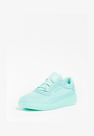 Zapatilla de color verde menta claro, hecha de malla y goma, con punta redondeada, detalles texturizados y cordones planos. Nombre de la marca grabado en el lateral.