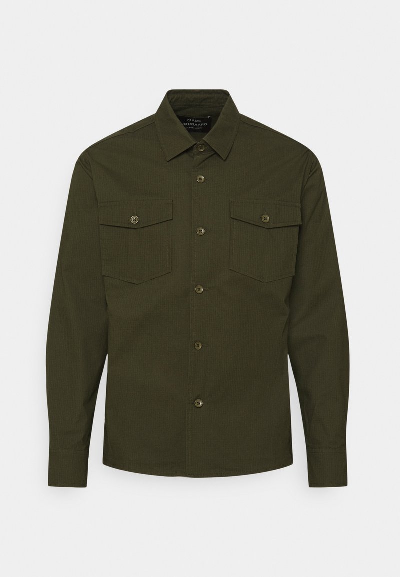 Chemise boutonnée à manches longues vert foncé avec col et deux poches poitrine boutonnées, présentée sur un fond blanc.