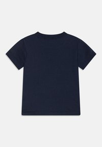 Marineblauwe T-shirt met korte mouwen van katoen. Heeft een ronde halslijn en een effen achterkant met stikdetails langs de zoom en mouwen.