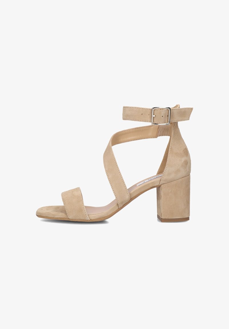 Beige suede heeled sandals with a block heel, open toe, and crisscross ankle straps featuring a metal buckle and smooth texture.