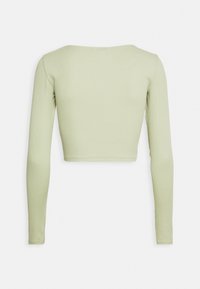 Top cropped de manga longa verde claro com decote redondo. Textura ribada suave, costuras limpas e silhueta ajustada.