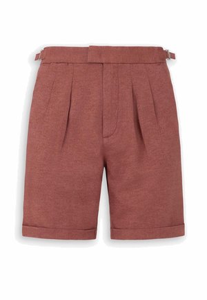Pantaloncini sartoriali color ruggine con pieghe, orli risvoltati e cinturini laterali regolabili con fibbia su sfondo bianco.