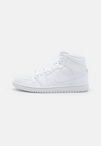 Bílé vysoké tenisky Nike s tkaničkami, perforovanou špičkou a ikonickým logem swoosh na boku, umístěné na jednoduchém bílém pozadí.