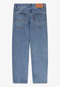 Ljusblå denimjeans med rak bendesign, bakfickor och en läderlogotyp på midjan.