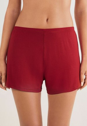 Röda bomullsshorts med elastisk midja, med en slät yta och en klassisk snitt som slutar ovanför mitten av låret. Inga mönster eller detaljer.