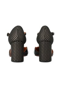 Scarpe nere con tacco alto e un motivo testurizzato a pois, dotate di una cintura alla caviglia e di un tacco largo e solido.