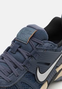 Blaue Mesh- und Wildledersneaker mit strukturierten Details, grauen Akzenten und heller Sohle. Verfügt über geflochtene Schnürsenkel und silbernes Logo.
