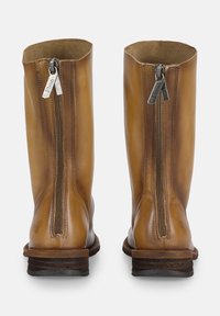 Stivali in pelle marrone con gambali alti, cerniere verticali sul retro e tacco alto. Texture liscia con accenti di cucitura minimi.
