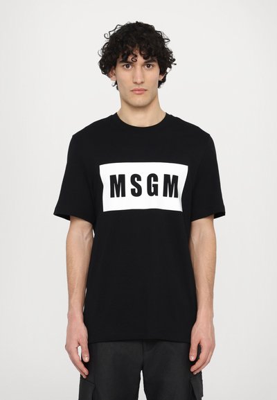 Fekete pamut póló rövid ujjú, fehér téglalap alakú grafikával, amelyen a "MSGM" szöveg vastag fekete betűkkel szerepel.
