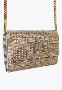 Borsa a tracolla con catena in tono oro, rivestita di piccole decorazioni in oro e cristallo, con una chiusura decorativa che assomiglia a un pavone.