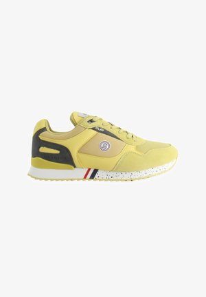 Baskets jaunes en matériaux suédé et en mesh, avec des accents noirs, un logo circulaire et un design de semelle tacheté blanc et rouge.