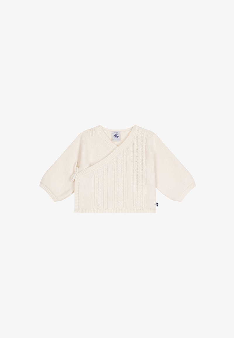 Pull bébé tricoté couleur crème avec devant croisé, manches longues, fermeture latérale à nouer et motif torsadé vertical sur le devant.