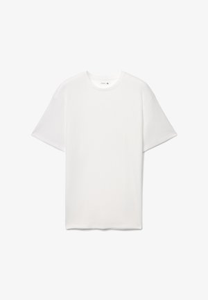 T-shirt bianca a maniche corte in tessuto strutturato, con scollo rotondo e taglio ampio. L'etichetta interna indica la taglia XL.