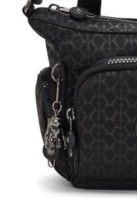 Black fabric bag with geometric pattern, featuring silver hardware, zippers, and a keychain charm. Compact, structured shape.