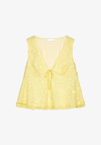 Top amarillo sin mangas con escote en V profundo, bordado floral, detalle de lazo en el centro y forma acampanada. Tejido transparente y texturizado.