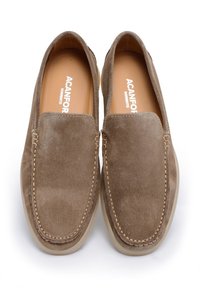 Brązowe zamszowe loafersy z detalem w postaci przeszyć, okrągłym noskiem i lekką, beżową gumową podeszwą. Wnętrze zawiera beżową wkładkę z brandingiem.