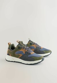 Sneakers charakteryzują się połączeniem szarych, oliwkowozielonych i brązowych materiałów, z siateczkową cholewką, wyściełanym kołnierzem, sznurowanym przodem i białą podeszwą.