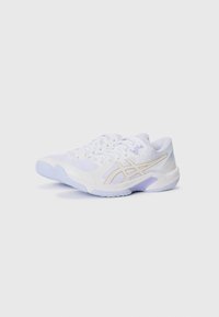 Baskets blanches avec une tige texturée, comportant des accents dorés et une semelle flexible bleu clair. Les lacets et un col rembourré sont visibles.