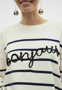 Pull blanc avec des rayures horizontales bleu marine, portant "bonjour" en broderie noire. Le tissu semble doux, avec un col rond.