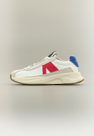 Weißer Sneaker mit roten Akzenten und blauem Fersenteil, aus einer Kombination von Mesh- und Wildledermaterialien, mit strukturierter Sohle und Schnürdesign.