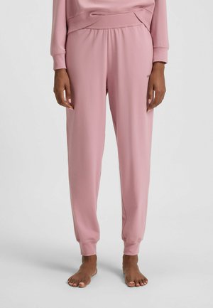 Pantaloni della tuta rosa realizzati in tessuto morbido, con vita elastica, gambe affusolate e orli rifiniti. Dettaglio di branding minimale sul davanti.