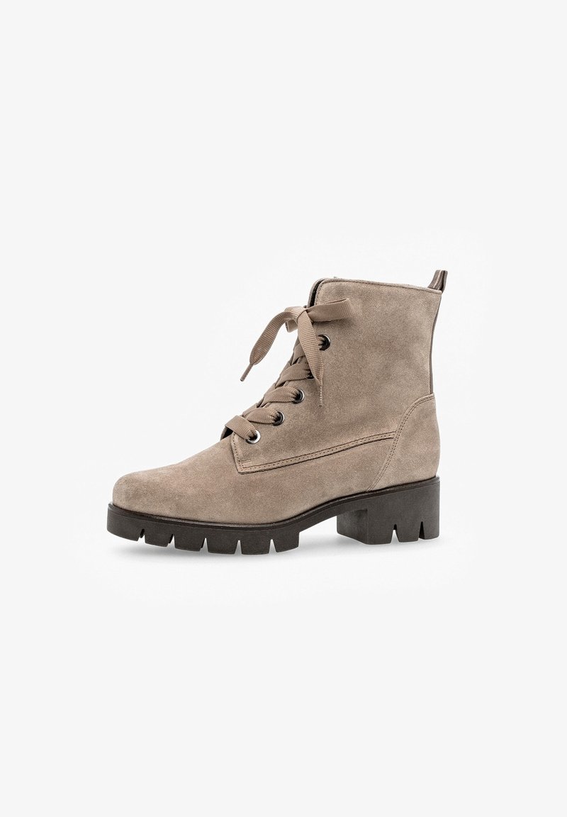 Bottine en daim taupe avec fermeture à lacets sur le devant, semelle épaisse noire à crampons et languette de tirage à l'arrière.