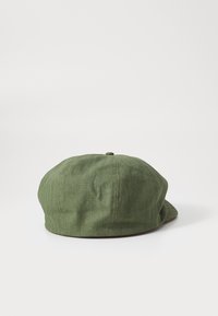 Casquette en tissu vert avec une couronne arrondie, surface texturée et visière courbée. Présente un détail en bouton sur le dessus et une bordure contrastante.
