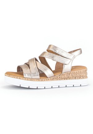 Metallische gouden wedge-sandaal met kruislings verstelbare banden, kurken tussenzool en witte rubberen outsole. Open ontwerp voor ademend vermogen.