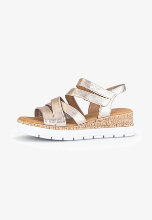 Metallische gouden wedge-sandaal met kruislings verstelbare banden, kurken tussenzool en witte rubberen outsole. Open ontwerp voor ademend vermogen.