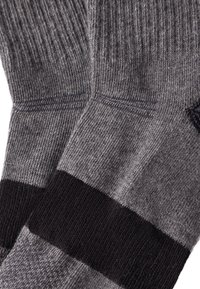 Villa sekoottisukat harmaana, joissa on uritettu pinta. Niissä on mustat raidat sekä vahvistettu kanta ja varvas kestävyys huomioiden.