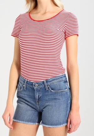 T-shirt à manches courtes à rayures rouges et blanches avec un col arrondi, associée à un short en denim bleu avec un ourlet effiloché et des poches avant.