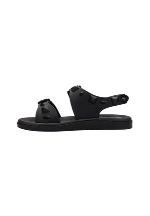 Sandali in gomma nera con un design aperto, borchie decorative, una suola spessa e una soletta testurizzata per il comfort.