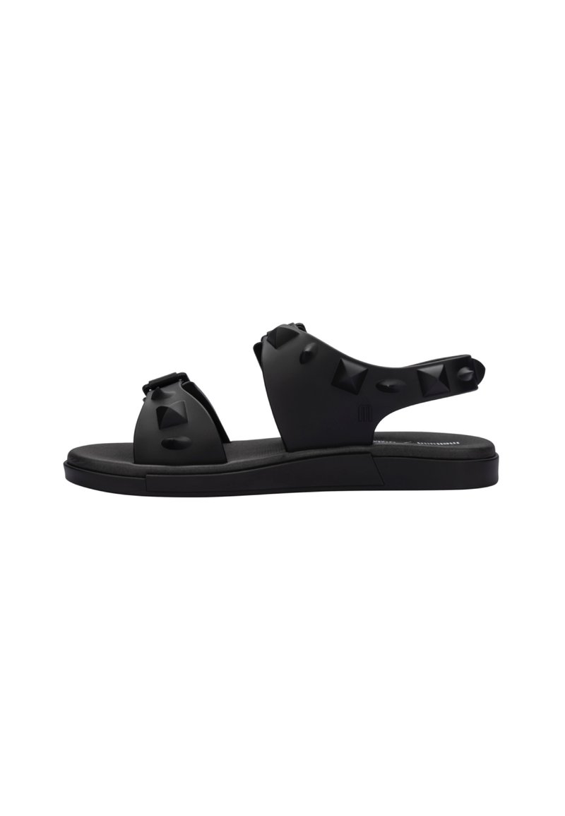 Sandali in gomma nera con un design aperto, borchie decorative, una suola spessa e una soletta testurizzata per il comfort.