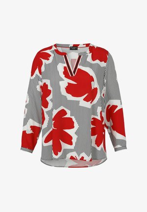 Blouse blanche avec des rayures verticales noires et de grands motifs floraux abstraits rouges, dotée d'un col en V et de manches longues.