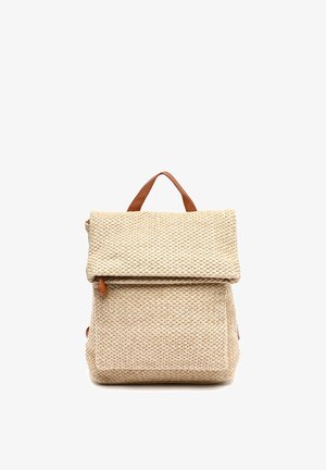 Beige geweven stoffen rugzak met grote klep en bruine leren hendel bovenop, weergegeven tegen een witte achtergrond.