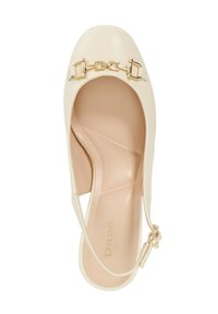 Beige hoge hak schoen gemaakt van glad materiaal met een gouden kettingaccent op de teen en een verstelbaar bandje bij de enkel.