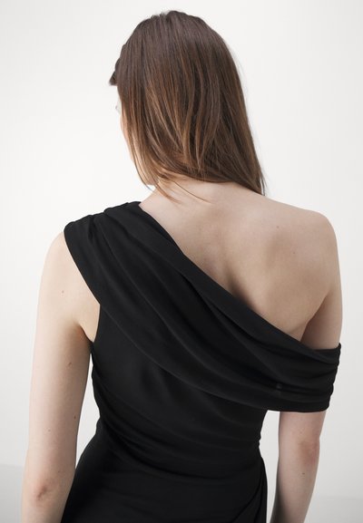 Rochie neagră cu un design drapat, cu un umăr. Țesătură netedă, cu o textură moale, evidențiind silueta umărului și a spatelui.