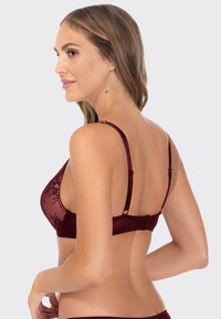 Burgundowa koronkowa bielizna z regulowanymi ramiączkami, głębokim dekoltem w kształcie litery V oraz gładkim pasem z tyłu z zapięciem na hak. Teksturowana tkanina z subtelnym połyskiem.