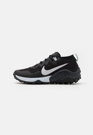 Black athletic shoe with mesh upper, white Nike swoosh, textured sole, and contrasting gray accents. Features traditional lace-up design.