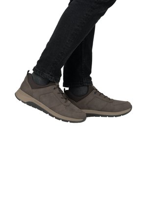 Braune, Wildleder-Sportschuhe mit niedrigem Profil, Schnürdesign, gepolstertem Schaft und kontrastierender Gummisohle, die auf einem weißen Hintergrund platziert sind.