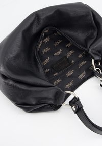 Zwarte gepolsterde leren handtas geopend om de zwarte stoffen binnenkant te tonen met herhaaldelijke "Venezia Made in Italy" branding en een ritsvak.