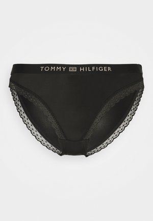Black panties with lace trim on sides. Features logo waistband in contrasting cream color. Smooth texture and fitted design.