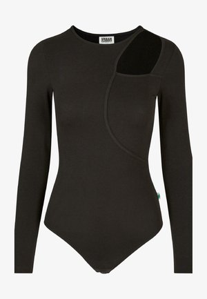 Fekete, hosszú ujjas bodyszut a puha anyagból, aszimmetrikus designnal, oldalzsebbel eltérő textúrával és patentos záródással az alján.